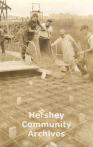 Teams of workers working on opposite sides of the Hershey Arena structure continuously poured concrete until they met at the top of arch, 1936