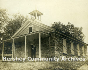 Charles Imboden , teacher, standing on Derry Church Schoolhouse porch, 1910