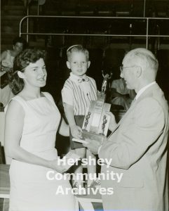 Hershey Park General Manager, George Bartels, presents the cutest baby award to Kyle Ann Katzenmoyer. 1956