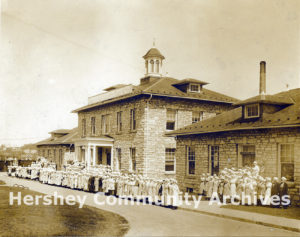 The wrapping department poses in front of Hershey Chocolate factory offices. 1915